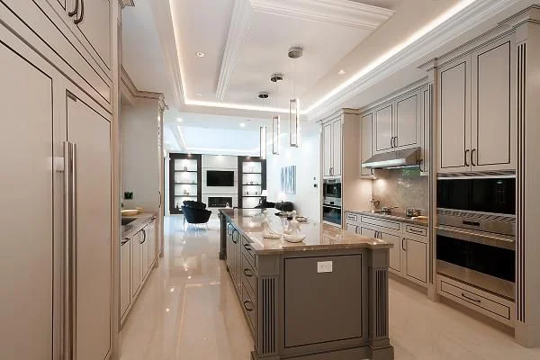 Elegant custom kitchen with island, pendant lighting, and coffered ceiling — designed by True Vision Construction